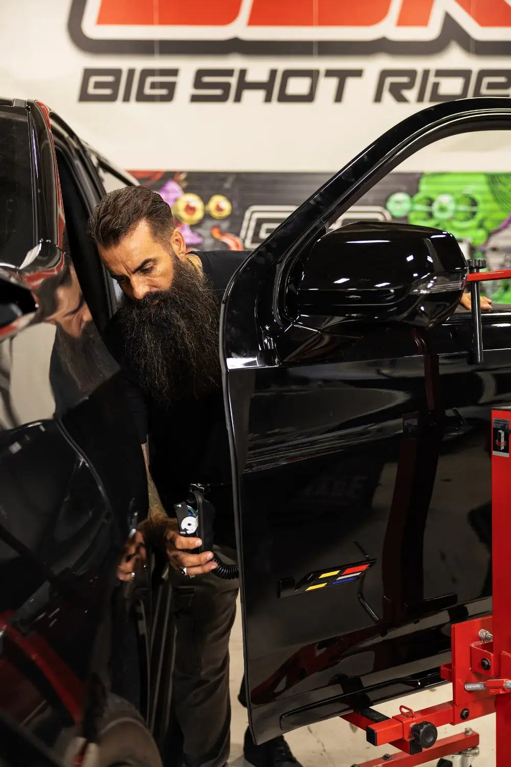 Chris Joerger working a Cadillac V-Series door on a stand at Big Shot Rides