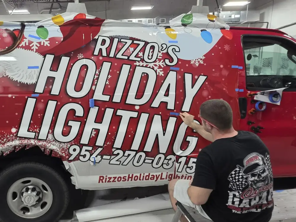 Rizzo’s Holiday Lighting van wrap being installed at Big Shot Rides, Coconut Creek FL