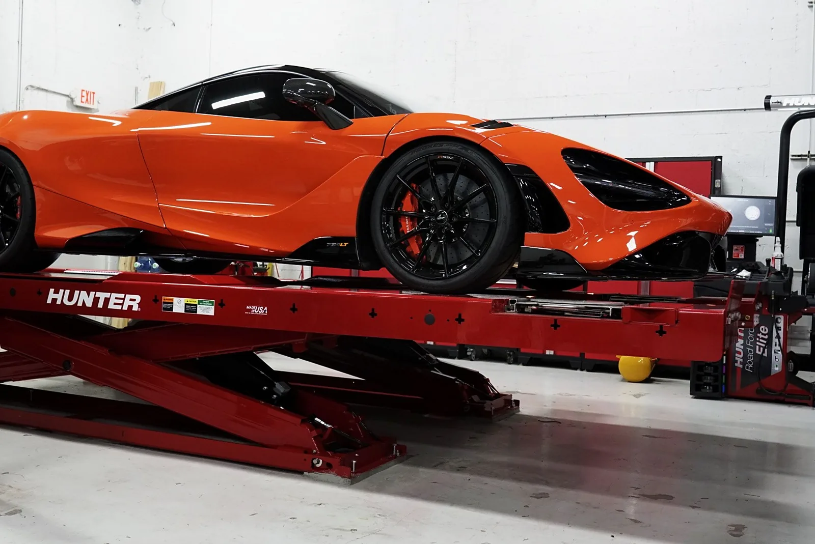 Orange McLaren 765LT on the Hunter Hawkeye alignment rack at Big Shot Rides Coconut Creek