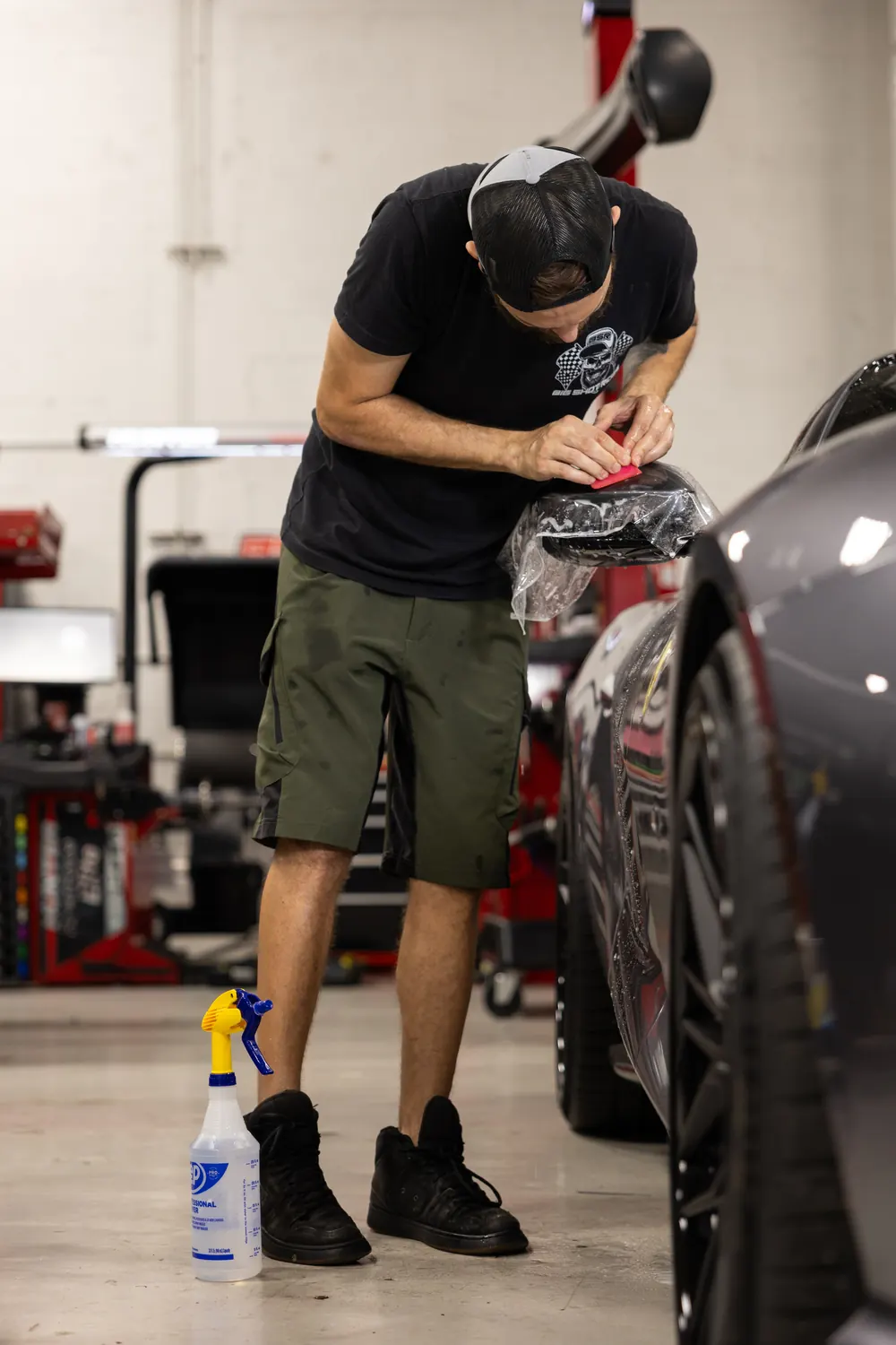 PPF being wet-fitted on a mirror at Big Shot Rides