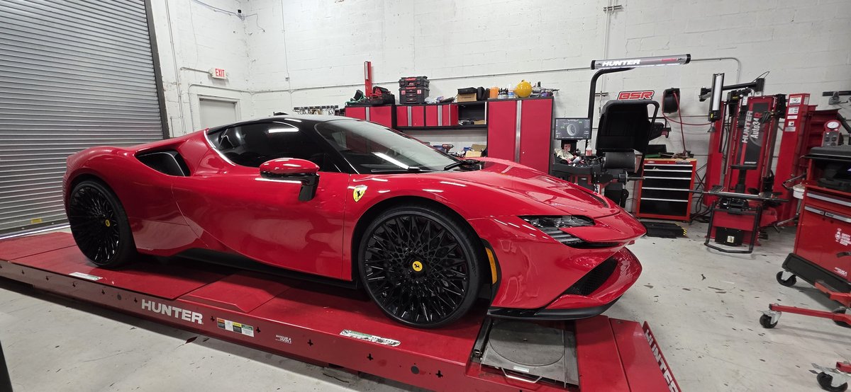 Red Ferrari SF90 on the Hunter alignment rack at Big Shot Rides in Coconut Creek FL