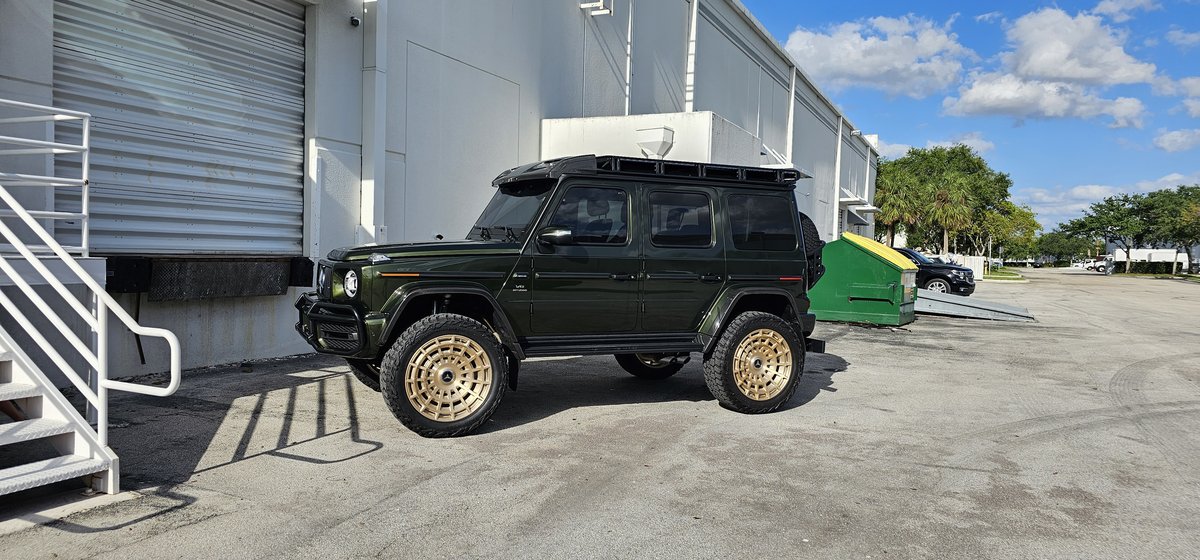 Green Mercedes G-Wagon with bronze wheels and roof rack at Big Shot Rides Coconut Creek FL